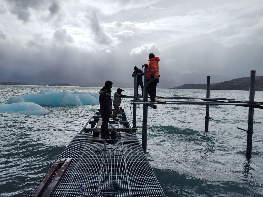 Equipo trabajando en la estructura del muelle, hielos al fondo